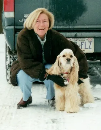 Person with dog in snowy parking area.