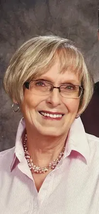 Smiling person with glasses and short blonde hair.