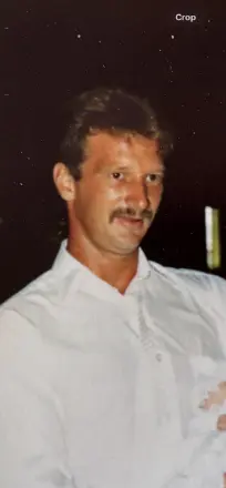 Man with mustache wearing white shirt, looking away