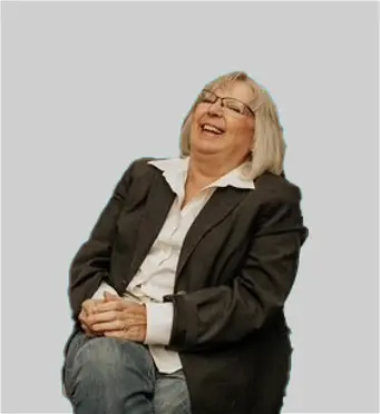 Smiling person sitting, wearing a suit.