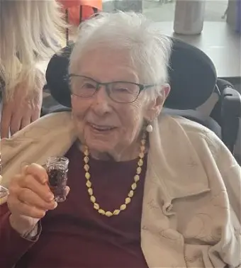 Elderly woman smiling with drink in hand