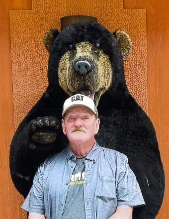 Man with bear statue in background.