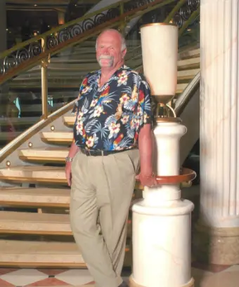 Man in Hawaiian shirt by staircase