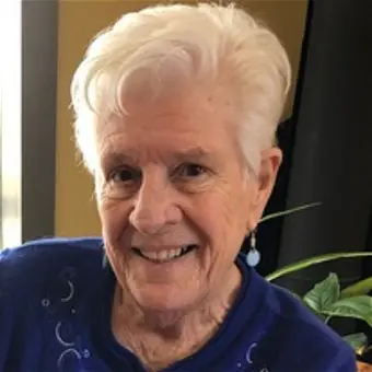 Smiling elderly woman in blue sweater.