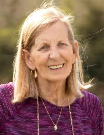 Smiling woman outdoors in purple top