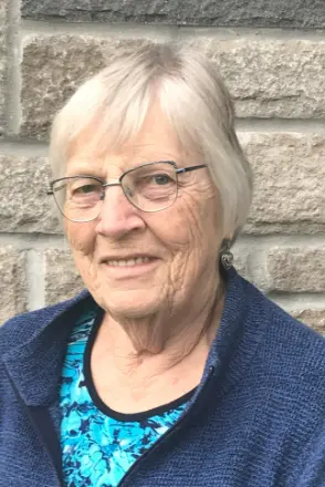 Smiling elderly woman in glasses and blue sweater