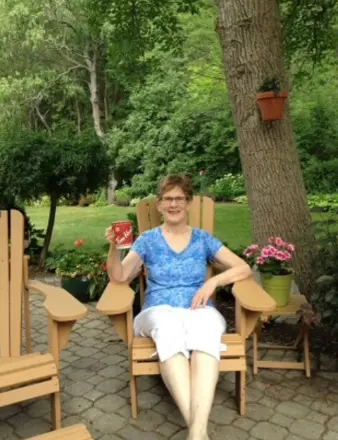 Woman relaxing with coffee in garden chair