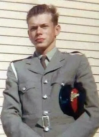 Young man in formal uniform with peaked cap.