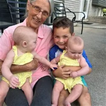 Smiling family with grandmother, child, and twin babies.