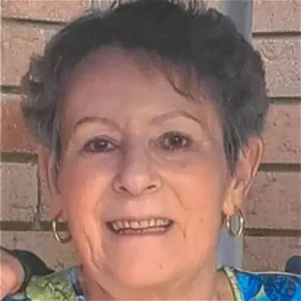 Smiling person in front of brick wall