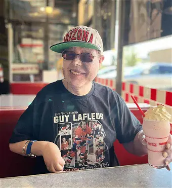 Person enjoying a milkshake at a diner.