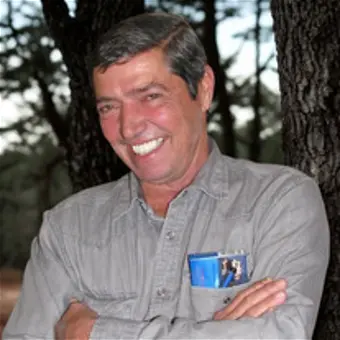 Smiling man outdoors near trees