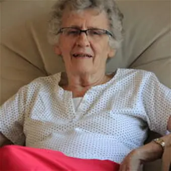 Smiling person sitting on a comfortable chair.