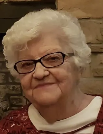 Elderly woman with glasses and short white hair.
