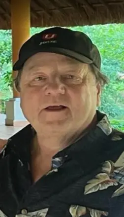 Person wearing floral shirt and cap outdoors