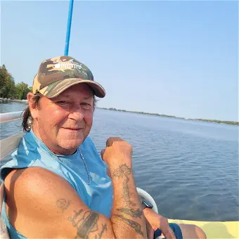 Man smiling on a boat in sunny lake