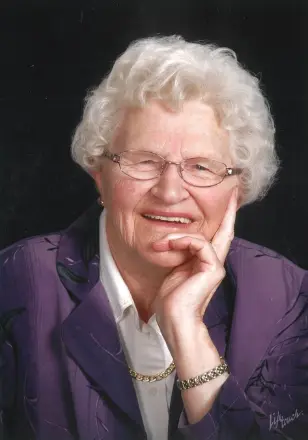 Elderly woman smiling in purple jacket