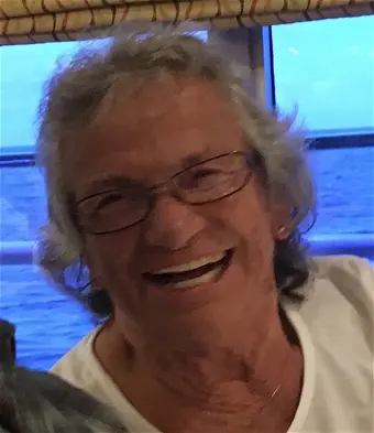 Smiling person on a boat with ocean view.