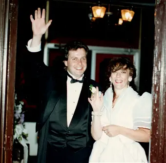 Couple in formal attire waving at event