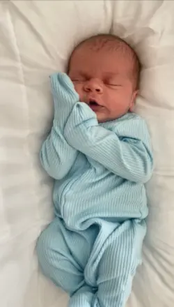 Newborn baby sleeping in blue outfit