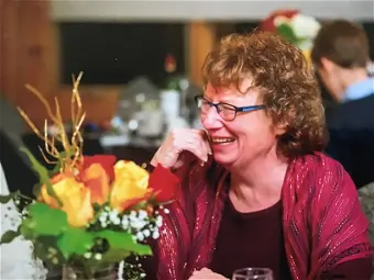 Smiling woman sitting at table with flowers