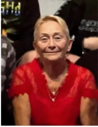 Smiling person in red shirt at event.