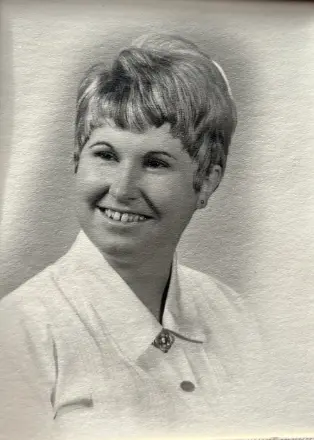 Woman smiling in black and white portrait.