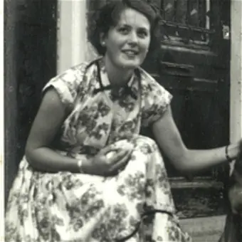 Woman in floral dress sitting with a dog.