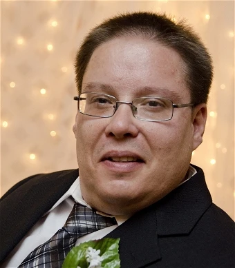 Man in suit smiling at a formal event.