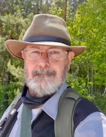 Man wearing hat and glasses in forest