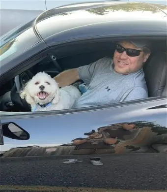 BROWN, Christopher Brown Man and dog inside a black sports car