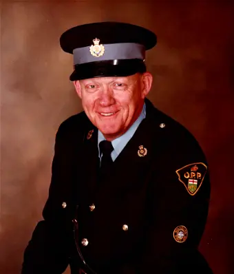 Uniformed police officer smiling for a portrait photo.