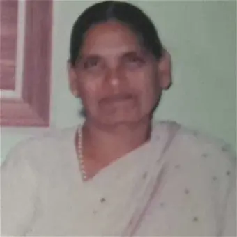Woman in traditional attire with light background.