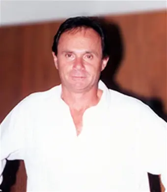Man in white shirt indoors, wooden background