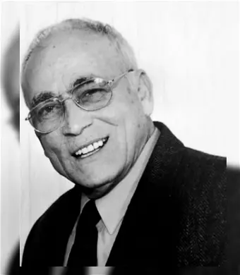 Smiling elderly man in glasses, black and white.