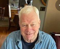 Smiling older man sitting in a cozy room.