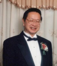 Smiling man in tuxedo with boutonniere at event.
