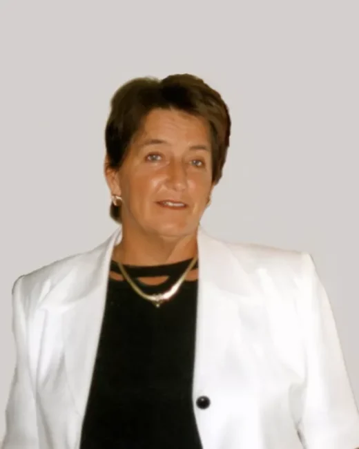 Person in white blazer with short hair.