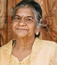 Smiling elderly woman with gray hair and earrings.