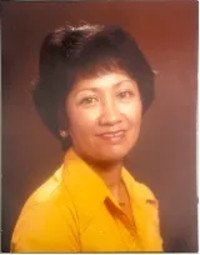Smiling woman in a yellow shirt, brown background.
