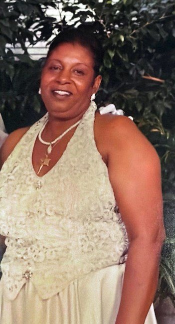 Smiling woman in elegant dress, outdoor setting.
