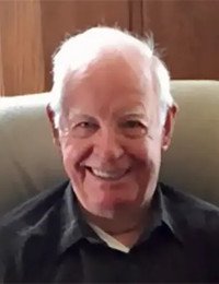 Smiling elderly man sitting in a chair.
