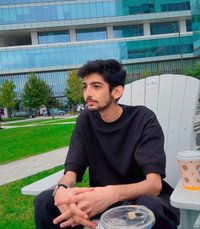 Person sitting outdoors with coffee.