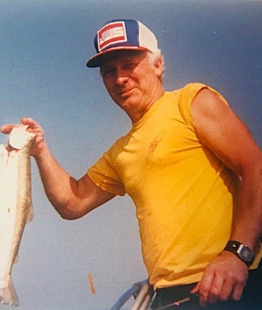 Man holding fish on boat in sunlight