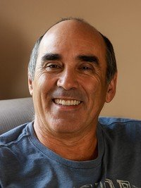 Smiling man sitting on a couch indoors.