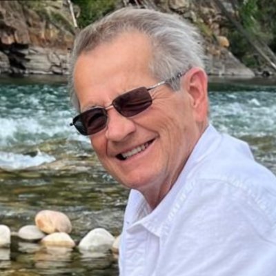 Smiling person by a river in nature.