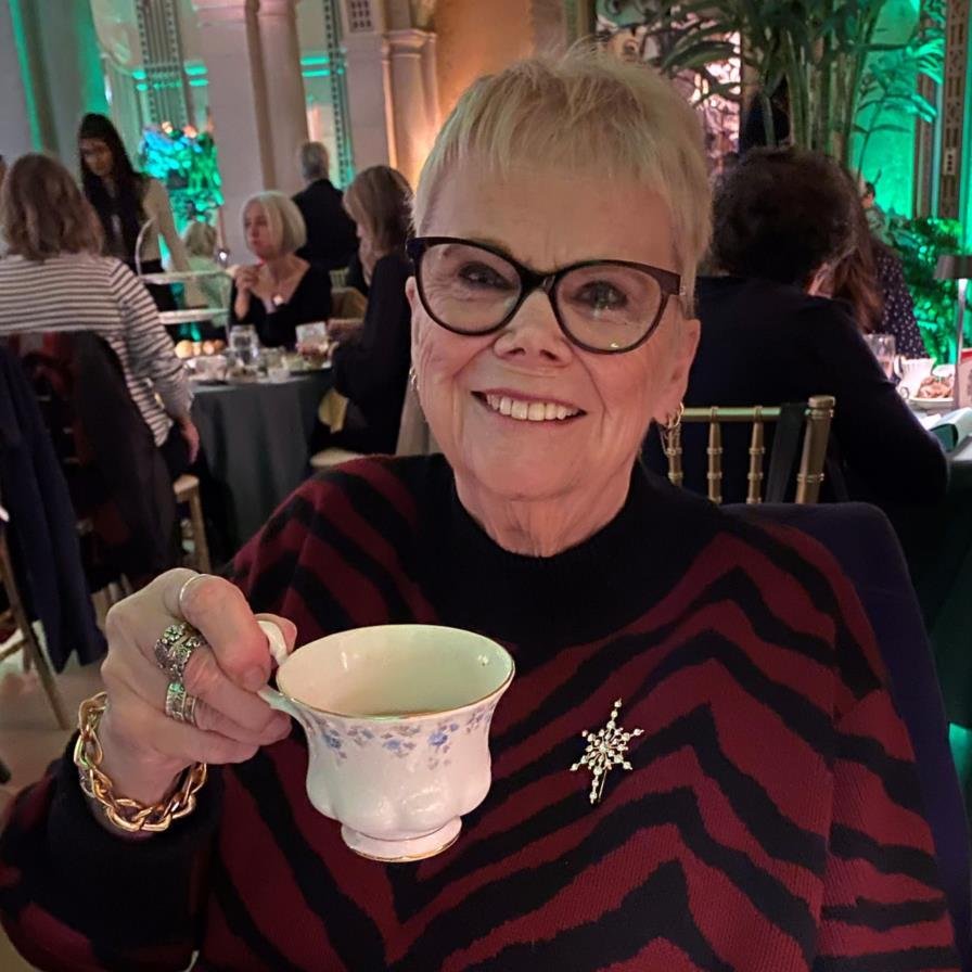 Smiling woman holding tea cup at event