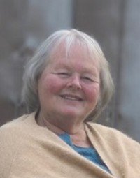 Smiling woman with gray hair and beige shawl