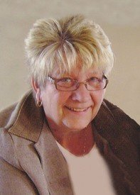 Smiling person with short hair and glasses.