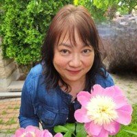 Woman smiling with large pink flowers